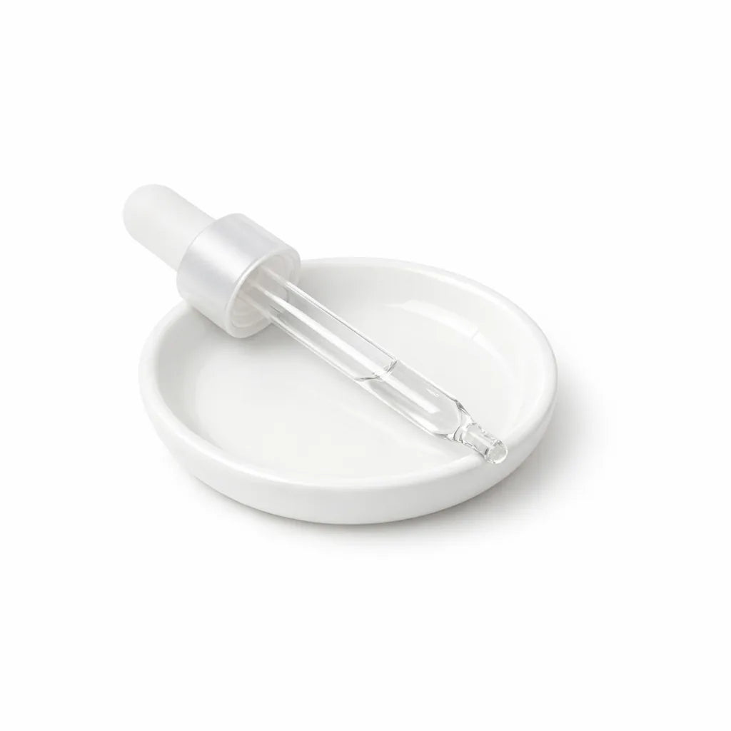 A laboratory dropper resting on white ceramic