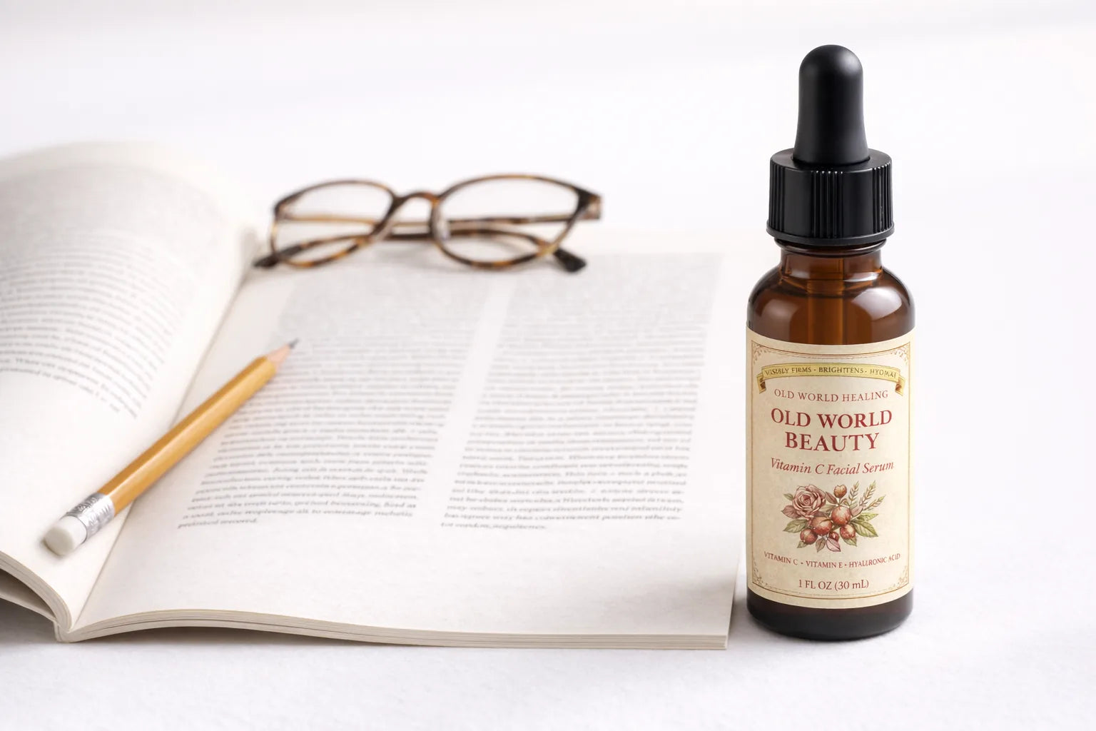 An open printed article on cream paper with a pencil and reading glasses