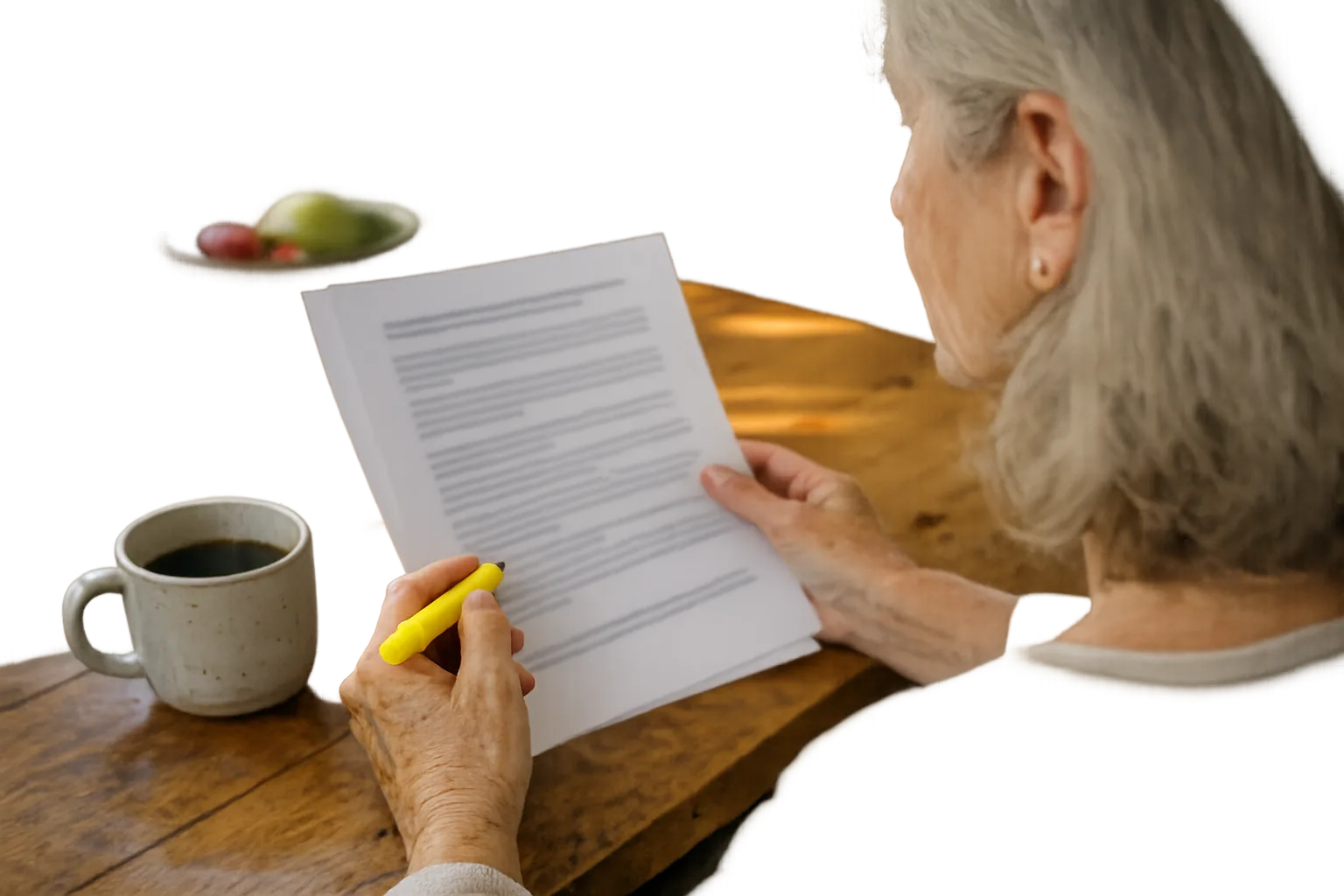 A woman in her sixties reading a printed article at her kitchen table